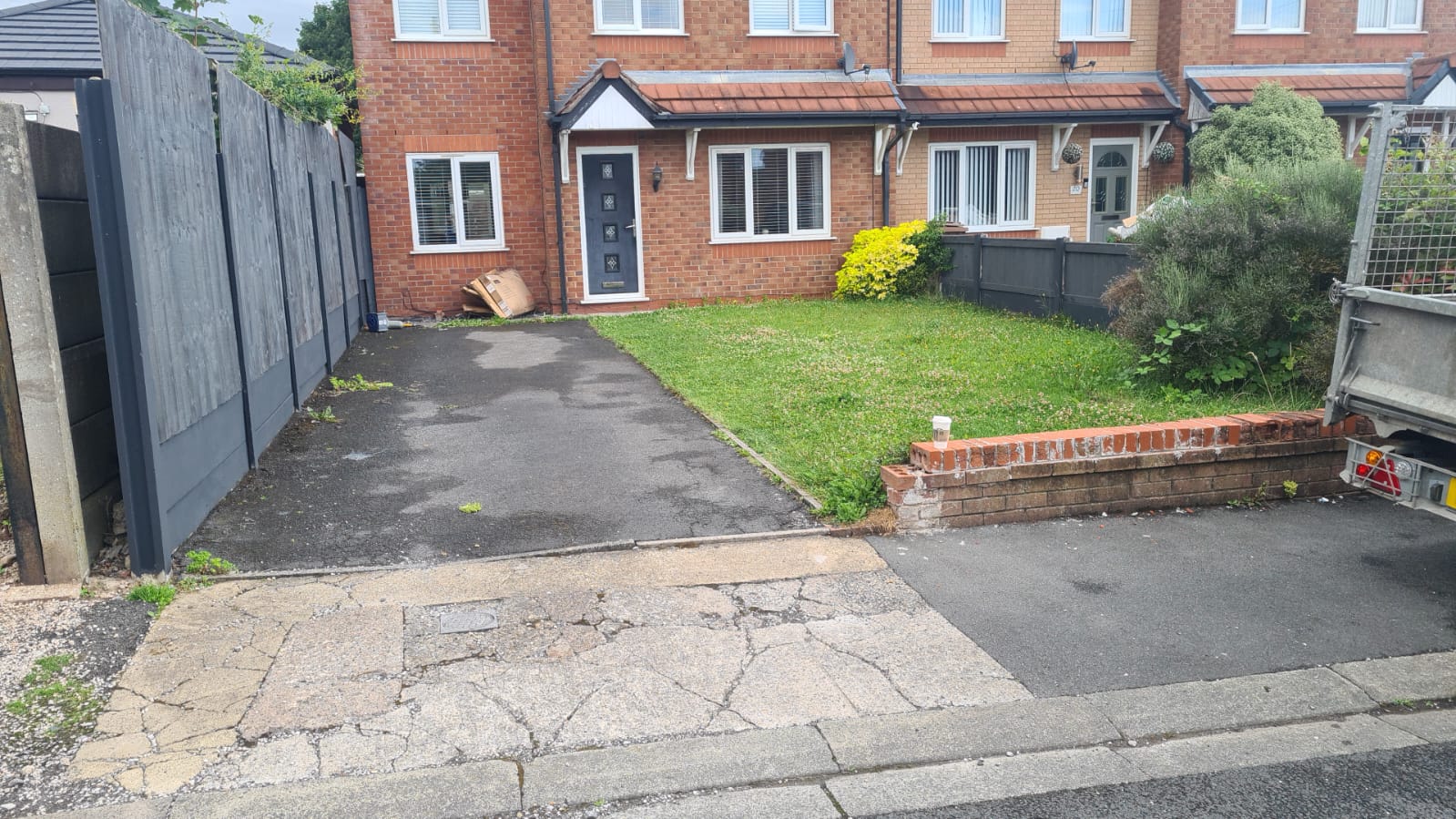 Before: a narrow existing driveway beside a front lawn and low brick wall